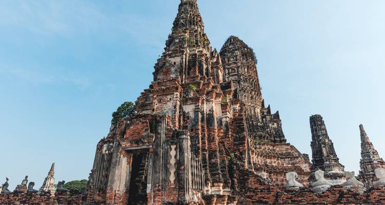 Towering prangs of Wat Chaiwatthanaram rise majestically against a clear sky.