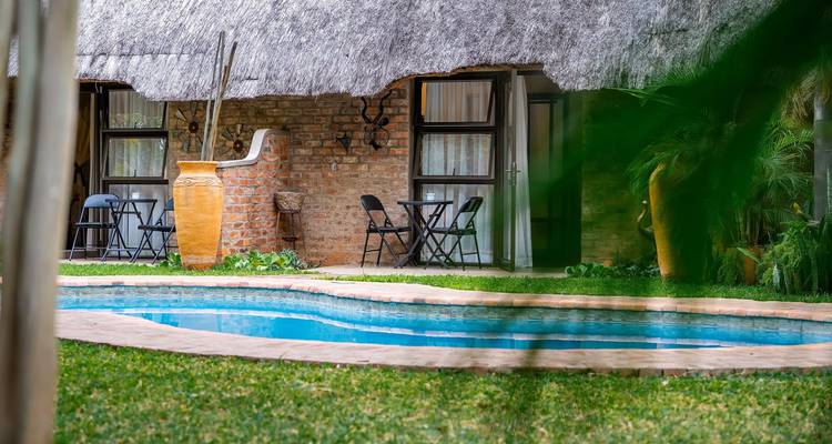Strohdachbungalow mit Zugang zu kleinem Swimmingpool und Gartenbereich