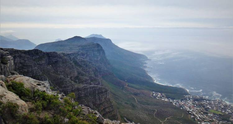 Hazy panoramic view from Table Mountain ridge looking over Atlantic coastline and distant peaks.