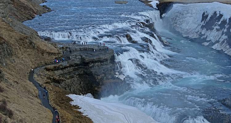 La puissante cascade de Gullfoss dévale à travers un canyon glacé avec des visiteurs sur le sentier en corniche