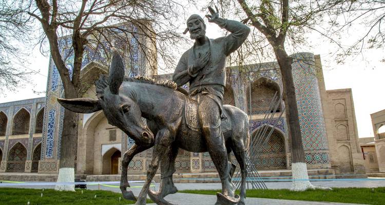 Estatua de bronce de Nasredín en un burro afuera de una madrasa histórica en Bujará