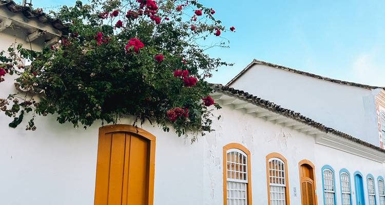 Colorful colonial house facade in Paraty with bright doors and blooming bougainvillea.
