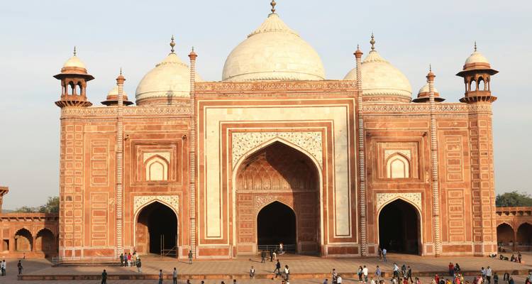 Nebenmoskee des Taj-Mahal-Komplexes, errichtet aus rotem Sandstein, mit Besuchern, die auf der Plattform spazieren.
