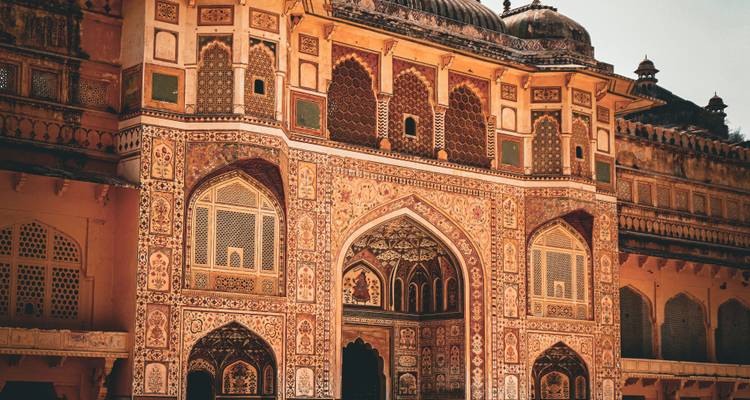 Ornately painted Ganesh Pol gateway at Amber Fort captured in warm light with intricate detail.