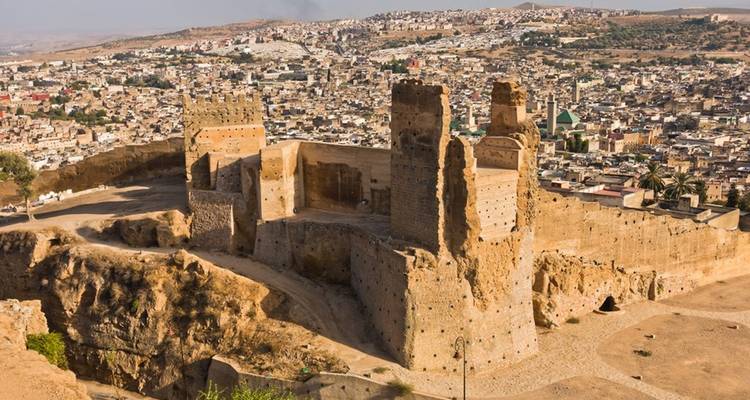 Forteresse en ruines perchée sur une colline dominant le vaste paysage urbain de Fès