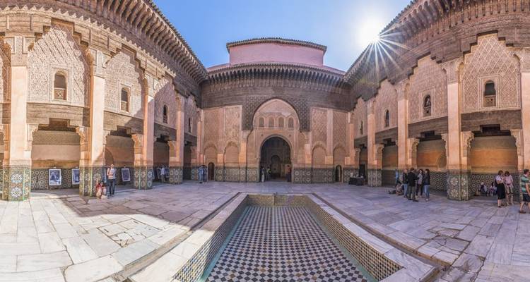 Cour ensoleillée de la Médersa Ben Youssef avec bassin carrelé et arches élaborées