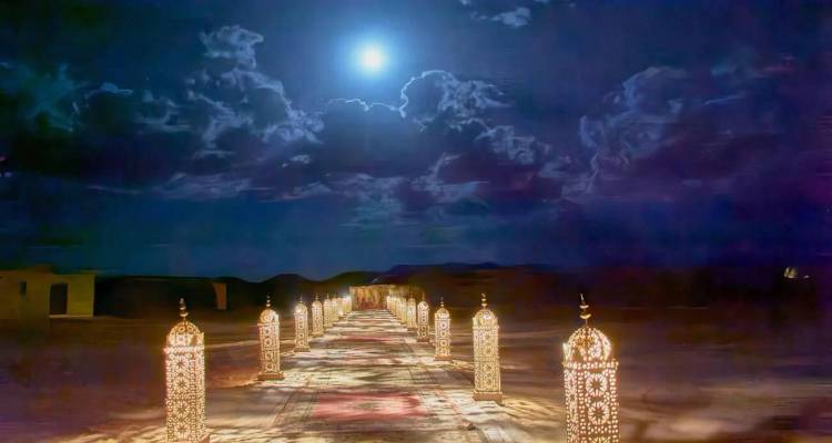 Scène nocturne d'une allée moquettée éclairée par des lanternes sous une pleine lune menant à l'obscurité du désert.