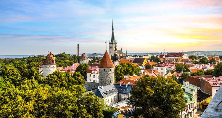 Vue panoramique du lever de soleil sur la Vieille Ville de Tallinn avec ses tours médiévales et son clocher d'église.