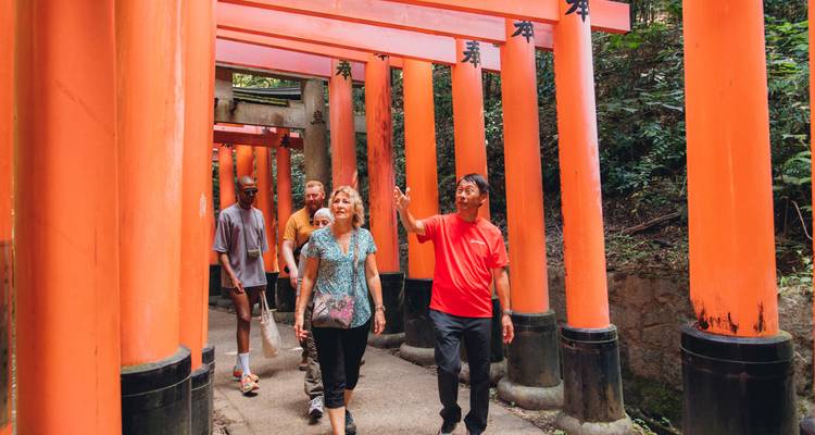 Bezoekers die door de felloranje torii-tunnel van Fushimi Inari Shrine wandelen.