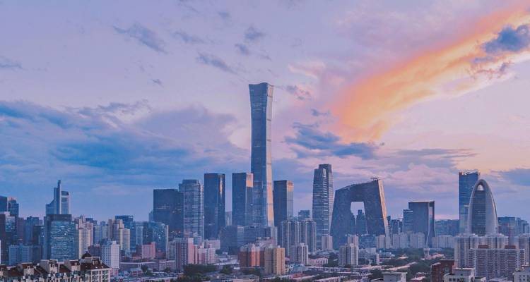 Moderne Beijing skyline bij schemering met CITIC Tower en iconisch CCTV Headquarters onder een kleurrijke wolkenstreep.