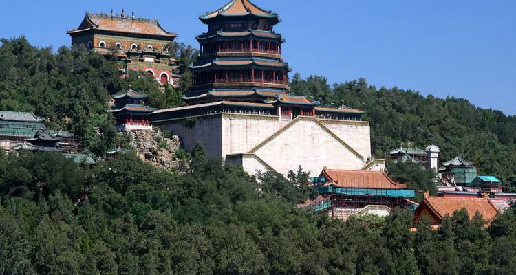 Historische gebouwen van het Zomerpaleis hoog op een groene heuvel met uitzicht op het bos in Beijing.