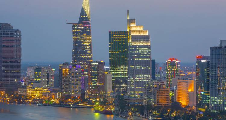 Skyline nocturne de Ho Chi Minh-Ville illuminée par des lumières colorées se reflétant sur le fleuve Saigon