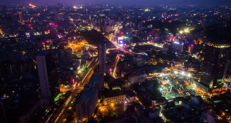 Luchtfoto van Ho Chi Minh-stad bij nacht, glociend met kleurrijke lichten en drukke avenue's