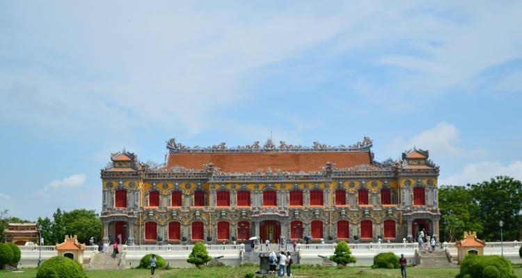 Breite Frontansicht des kunstvollen, farbenfrohen Palastgebaeudes Thai Hoa innerhalb der Zitadelle von Hue vor blauem Himmel