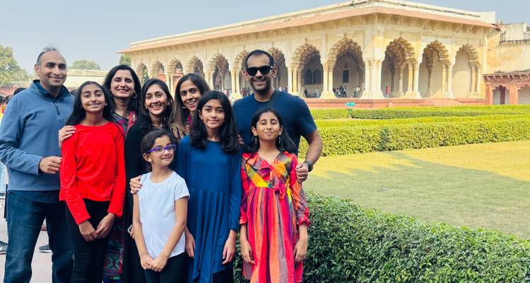 Multi-generational family posing in front of ornate arches in Agra Fort gardens