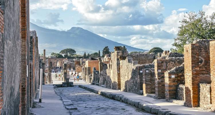 Antike Steinstraße von Pompeji mit dem drohenden Mount Vesuv im Hintergrund.