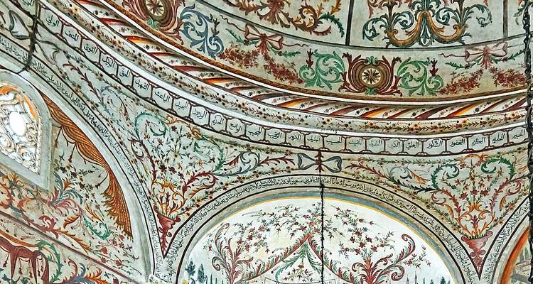 Kleurrijk Ottomaans geschilderd plafond met ingewikkelde bloemen- en kalligrafische motieven
