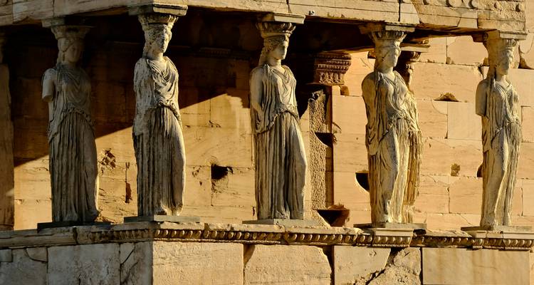 Detailed close-up of the Caryatids supporting the Erechtheion porch lit by warm afternoon light.