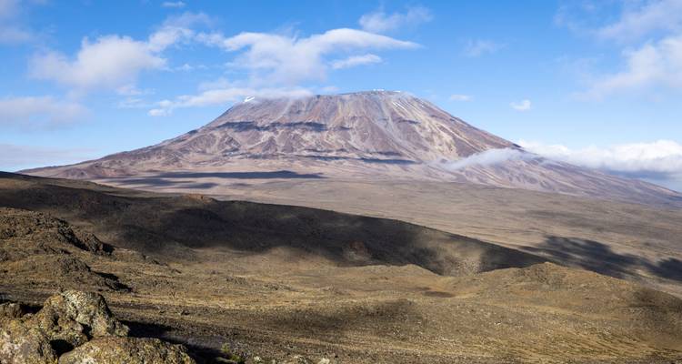Clear view of Mount Kilimanjaro’s summit with blue sky and sweeping volcanic slopes.