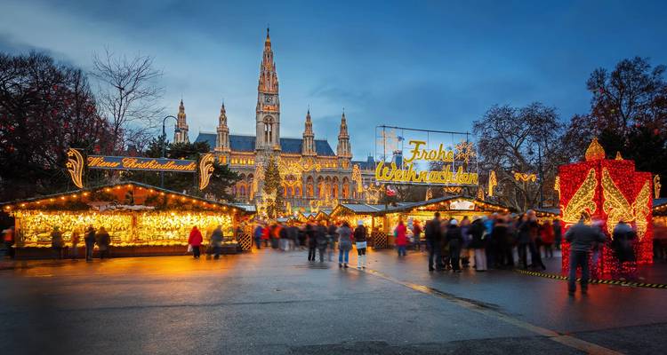 Festive Christmas market lights sparkle before Vienna’s illuminated Rathaus at dusk
