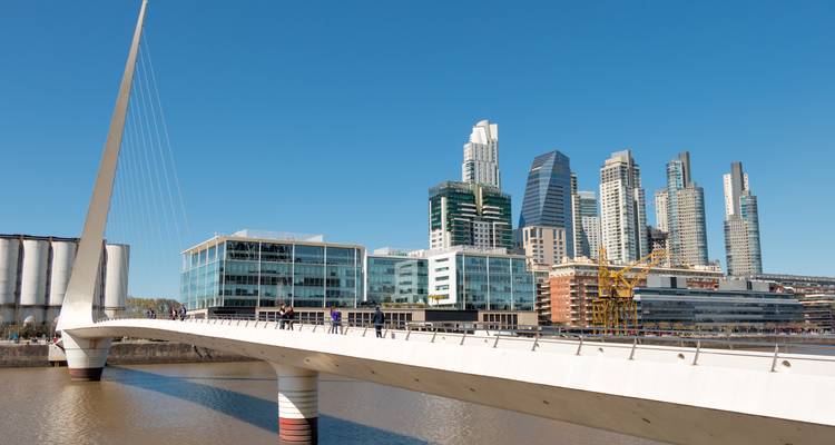 De moderne skyline van Puerto Madero achter de slanke witte Puente de la Mujer voetgangersbrug die zich uitstrekt over de dokken.