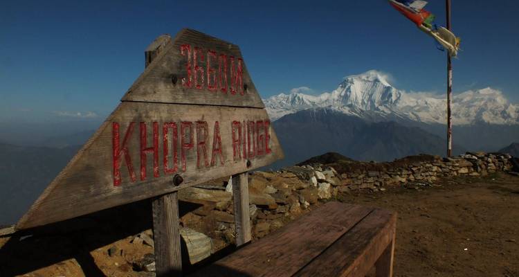 Panneau de crête de Khopra en bois avec un imposant pic enneigé en arrière-plan.
