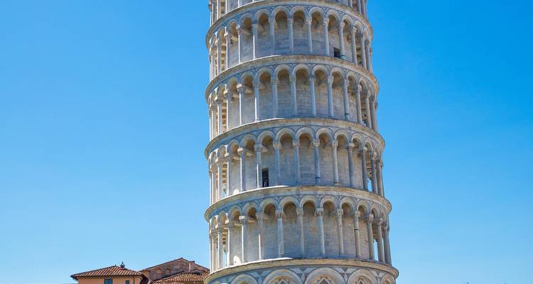 La icónica Torre Inclinada de Pisa erguida contra un cielo azul despejado.