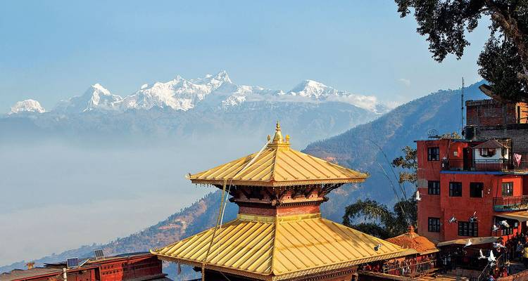 Golden-roofed hilltop shrine set against a dramatic Himalayan snow-covered range and hazy valley below.