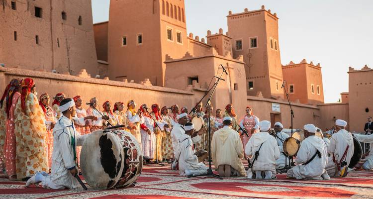 Traditional Moroccan music and dance performance in a kasbah courtyard at sunset