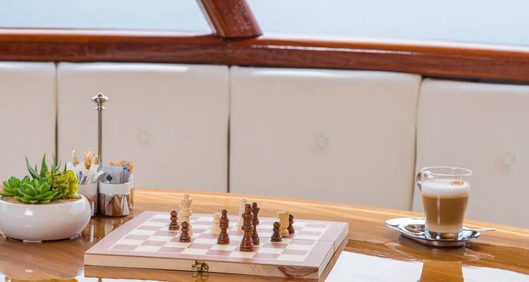 Holztafelverkleideter Loungetisch mit Schachbrett, Latte und Sukkulente auf einem Kreuzfahrtschiff.