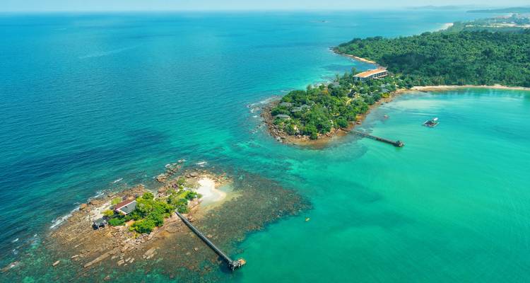 Aerial view of two lush tropical islets surrounded by vivid turquoise waters off Vietnam.