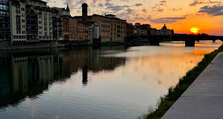 Sunset over the Arno River with historic riverside buildings and their reflections, Florence.
