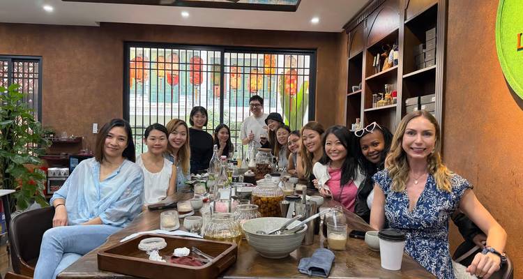 Group of travellers seated around a wooden table in a Hanoi cafe for a tasting session.