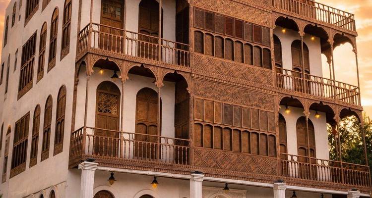 Traditioneel Hijazi koralen stenen huis met sierlijke houten balkons bij zonsondergang.