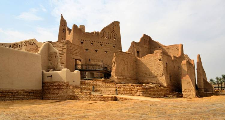 Muren en torens van ziegelstenen in de UNESCO-gelisteerde wijk At-Turaif in Diriyah badbaden in zacht daglicht.