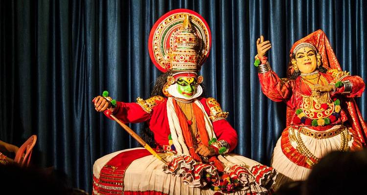 Vibrant Kathakali performers in elaborate red costumes and painted faces on stage