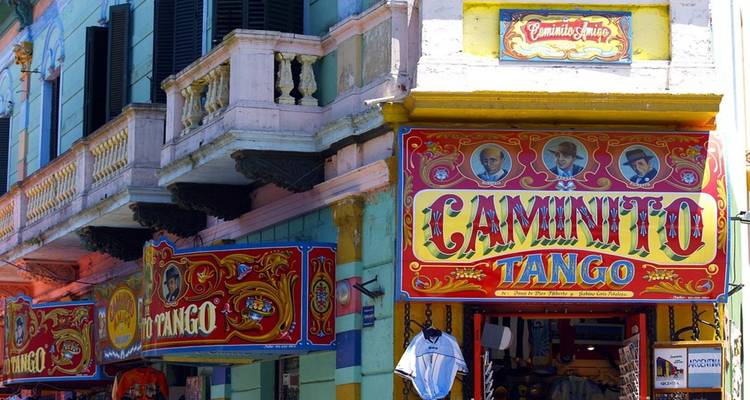 Brightly painted storefronts of Caminito with ornate signage celebrating tango culture.