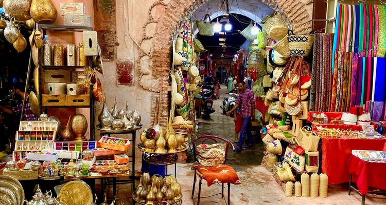 Eclectic display of brassware, baskets and spices at the entrance of a historic Moroccan bazaar.