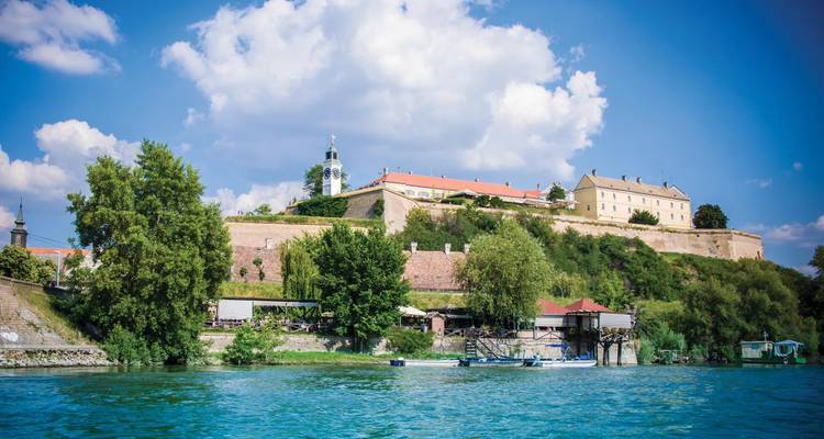 Petrovaradin Fortress overlooking the Danube River with bright summer skies.