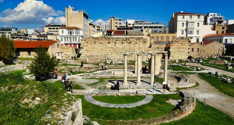 Archäologischer Stadtpark mit verstreuten Ruinen und Besuchern, die zwischen ihnen spazieren
