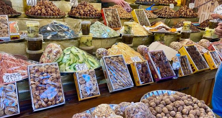 Innenstand mit sortiertem Trockenobst, Nüssen und Süßwaren, die in Tabletts und Beuteln verpackt sind.