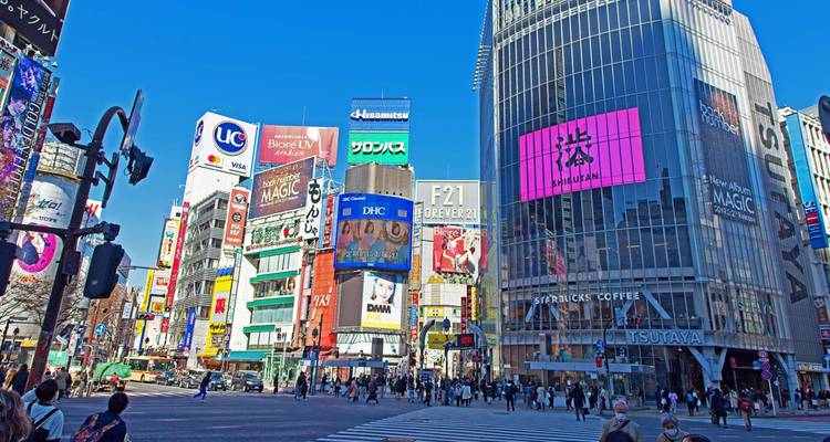 El bullicioso Cruce de Shibuya con letreros de neón, enormes edificios de vidrio y multitudes de peatones.