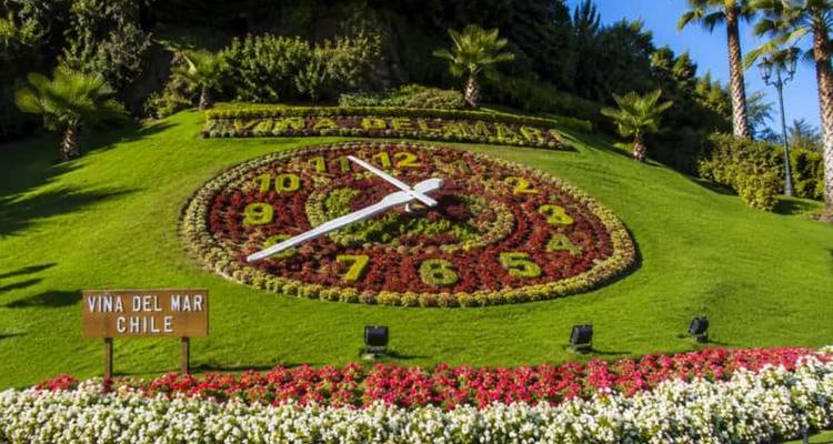 Landscaped flower clock reading 'Viña del Mar Chile' with bright floral numbers set on a manicured slope.