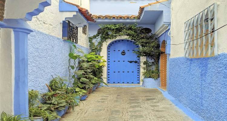 Une petite ruelle aux murs peints en bleu et aux portes ornementées à Chefchaouen.