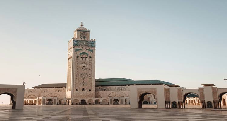 Vaste cour pavée de carreaux menant à la Mosquée Hassan II à l'aube.