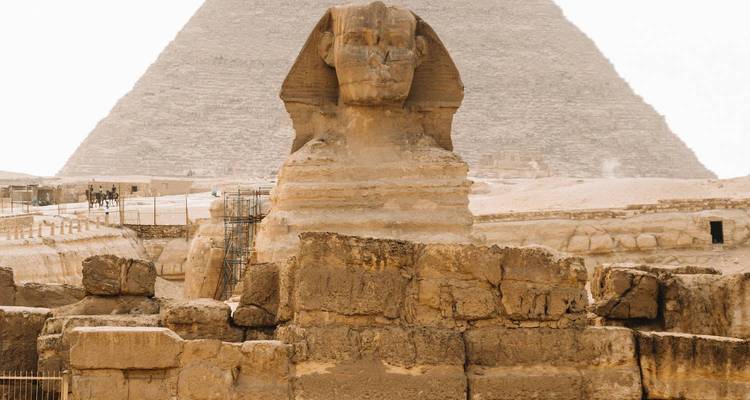 Front view of the Sphinx with a pyramid rising behind it