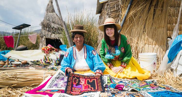 Femme locale et voyageur présentant des textiles faits à la main colorés sur l'île flottante d'Uros