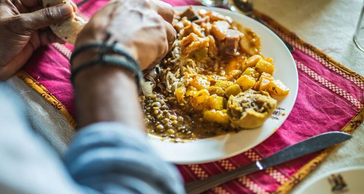 Gros plan d'une assiette de curry indien coloré avec des lentilles, du riz et des légumes.