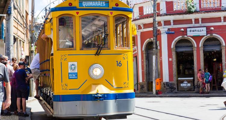 Bright yellow heritage tram in a historic neighborhood with colorful colonial buildings.