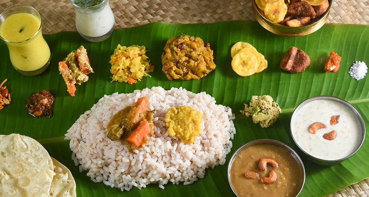 Traditional South Indian feast arranged on a banana leaf with diverse curries and desserts.